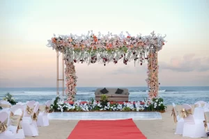 A beach indian wedding ceremony in Nusa Dua, Bali, featuring a red carpet leading to the altar by the ocean.