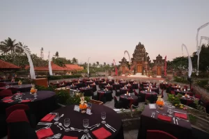 A large outdoor setting with tables and chairs, designed for an audience at a Balinese theater performance.