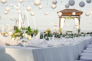 A beautifully decorated table with white linens and lanterns, creating an elegant and inviting ambiance